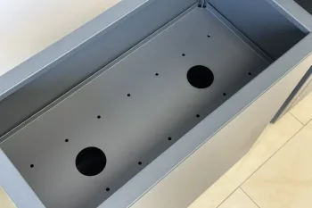 Polica za cvetlično korito 30×30 cm v antracit barvi, nameščena v koritu z odprtinami za lonce