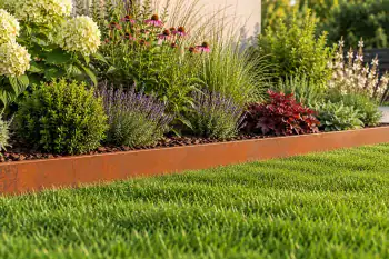 15 cm high Corten steel garden edging separating a lawn from a flower bed with ornamental grasses